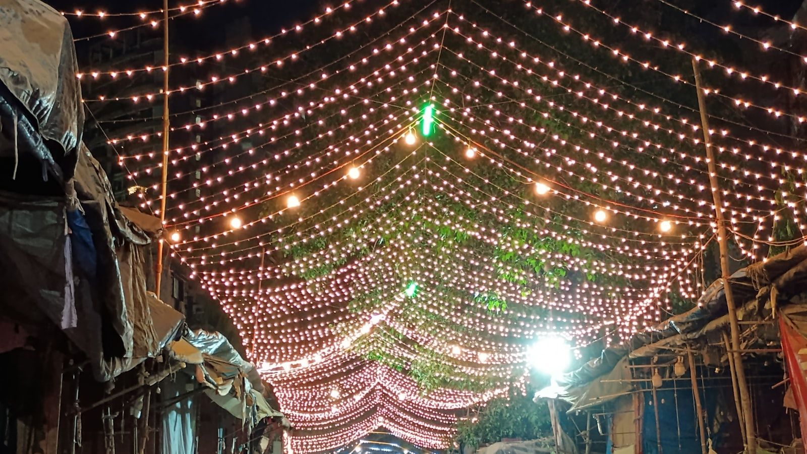 Guirlandes lumineuses tendues au-dessus d’une rue, le soir